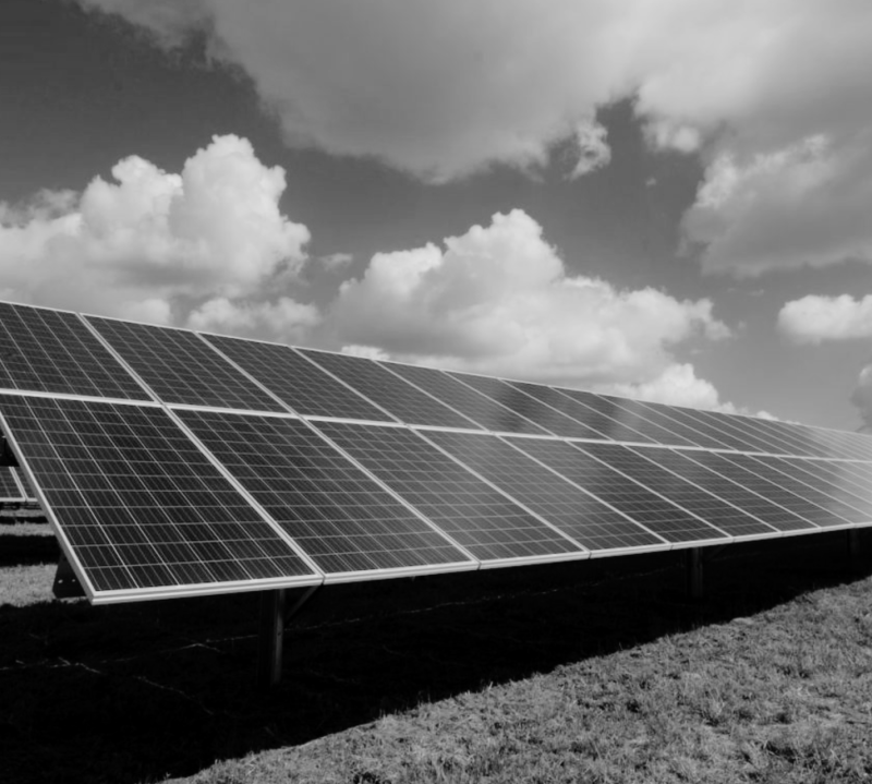Commercial solar panel installation in progress Large array of ground-mounted solar panels under a partly cloudy sky, showcasing renewable energy installation